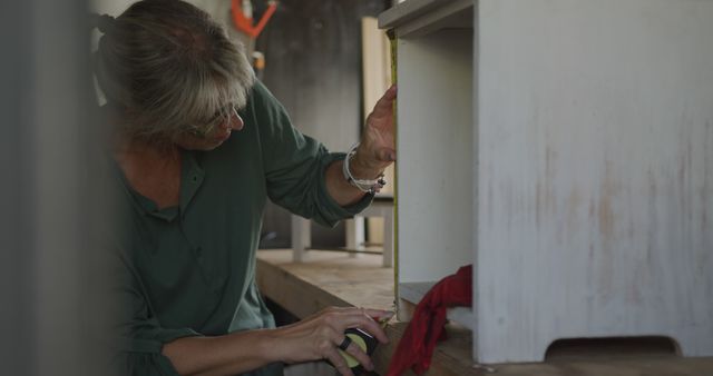 Woman measuring wooden furniture using tape measure - Download Free Stock Images Pikwizard.com