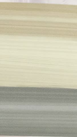 Vertical abstract video showing beige gray textured bands moving slowly in minimalist loop
