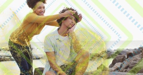 Couple enjoys playful moment by rocky shoreline
