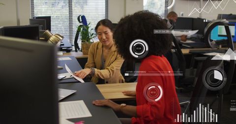 Business professionals discussing financial data with digital graphs