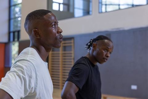 Two african american men training together in gymnasium focusing on teamwork and fitness