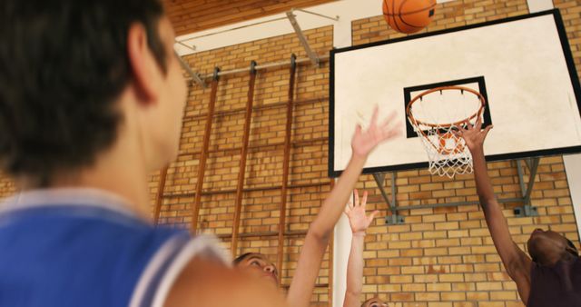 Players reaching for basketball under hoop in gym - Download Free Stock Images Pikwizard.com