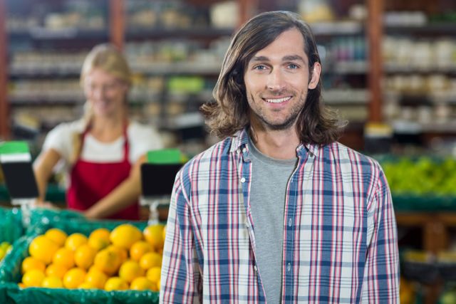 Portrait of smiling man standing in organic section of supermarket