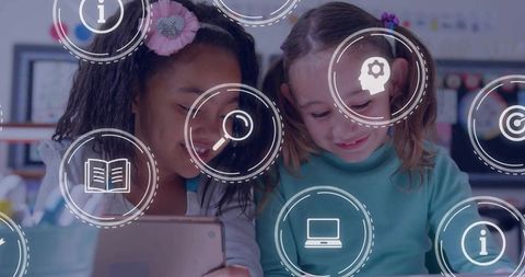 Diverse girls using tablet in classroom with digital education icons overlay for collaborative learn