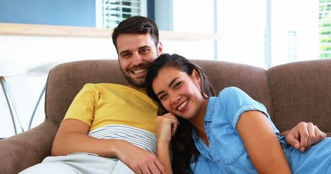 Smiling Couple Relaxing on Sofa in Cozy Living Room