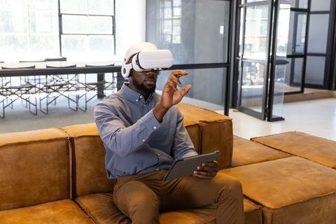 Man experiencing virtual reality wearing vr headset in modern office