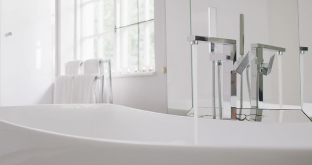 Modern minimalist bathroom featuring sleek chrome faucet and white sink. Ideal for use in interior design, home decor inspiration, bathroom renovation projects, and lifestyle magazines highlighting clean and contemporary home settings.