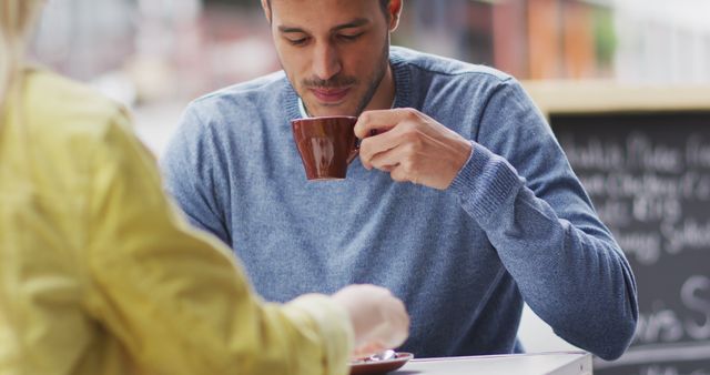 Man Drinking Coffee at Outdoor Café with Friend - Download Free Stock Images Pikwizard.com