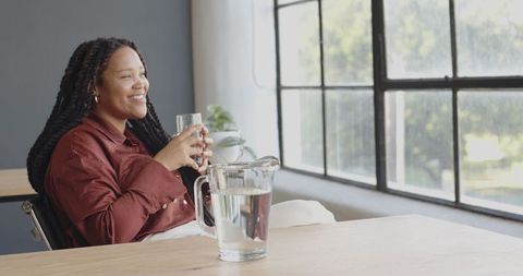 Businesswoman Enjoying Refreshing Drink by Office Window - Download Free Stock Images Pikwizard.com