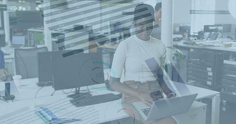 African American Businesswoman Analyzing Data on Laptop in Modern Office