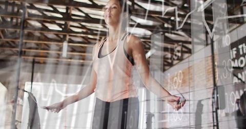 Woman skipping rope in industrial gym with data overlays for fitness technology campaign