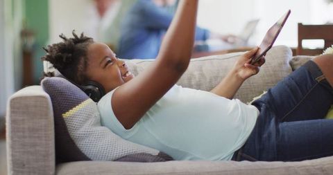 Joyful Girl Enjoying Tablet in Cozy Living Room