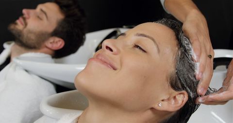 Clients relaxing during professional hair wash at salon