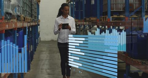 Warehouse manager walking and checking tablet while monitoring inventory analytics overlay