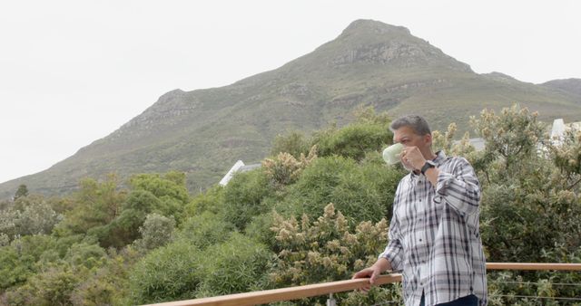 Man Drinking From Cup on Balcony Overlooking Mountain Scenery - Download Free Stock Images Pikwizard.com