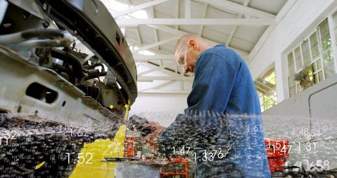 Mechanic repairing car bumper with digital diagnostic overlay in bright garage bay