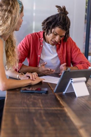 Diverse Coworkers Collaborating Over Office Document at Desk
