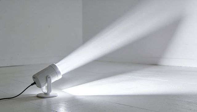 White led spotlight casting strong diagonal beam across minimal tiled corner with cord