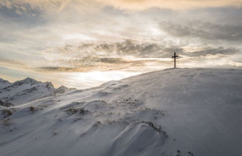 Majestic Winter Sunrise on Snowy Mountain with Cross
