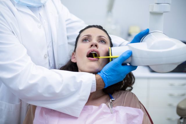 Dentist taking x-ray of patients teeth at dental clinic