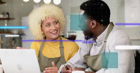 Diverse Coffee Shop Staff Collaborating Over Laptop