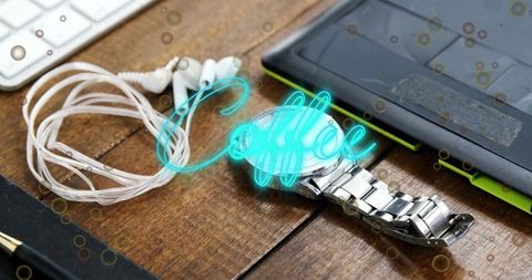 Work desk with silver watch and earphones highlighting coffee break