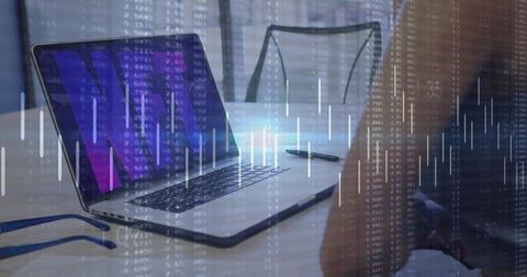 Laptop with purple financial charts and candlestick overlay on home desk with glasses