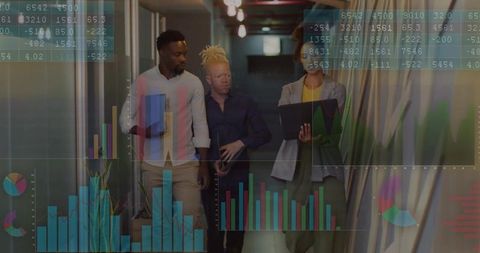 Business team walking while reviewing data in office hallway