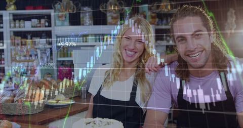 Smiling bakery owners celebrating sales growth with cake and artisan bread and stock chart