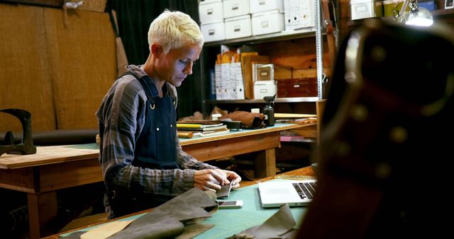 Craftsman Working in Workshop with Laptop and Leather Goods - Download Free Stock Images Pikwizard.com