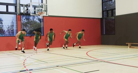 Young athletes playing fast-paced basketball game in indoor court