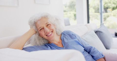 Senior Woman Relaxing at Home on Comfortable Couch
