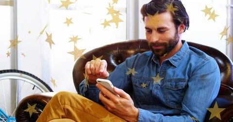 Man Relaxing at Home Using Smartphone in Cozy Urban Setting