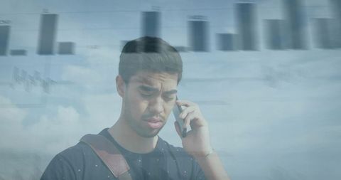 Worried young man holding smartphone and listening to call with financial chart overlay
