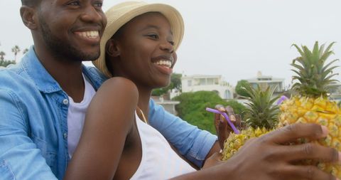 Couple enjoying refreshing pineapple drinks at beach