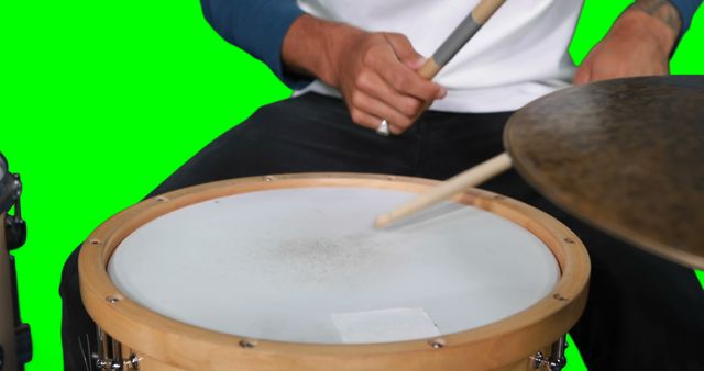 Mid section of drumer playing drum against green screen - Download Free Stock Photos Pikwizard.com