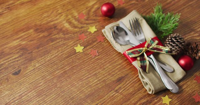 Image of christmas decorations with cutlery and copy space on wooden background. christmas, tradition and celebration concept.