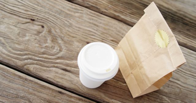 Takeaway coffee cup and brown paper bag on wooden surface - Download Free Stock Images Pikwizard.com