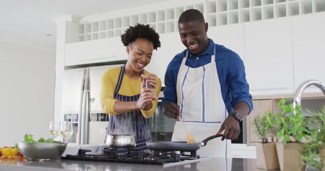 Image of happy african american couple cooking together. Love, relationship and spending quality time together concept.