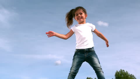 Joyful Girl Jumping on Trampoline in Clear Sky