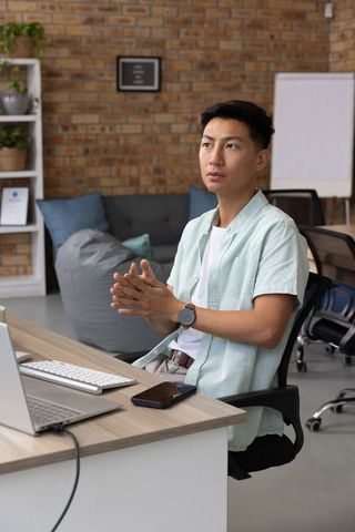 Asian Man Working in Modern Office with Industrial Design