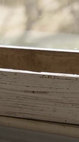 Handheld Vertical Shifting Focus on Weathered Painted Window Sill with Smudged Glass