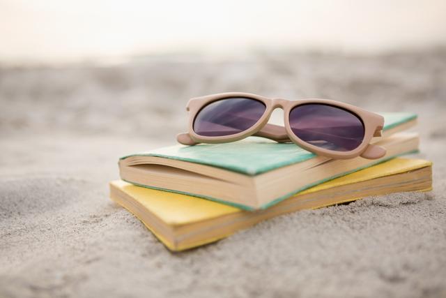 Sunglasses and Books on Sandy Beach at Sunset - Download Free Stock Photos Pikwizard.com