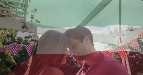 Romantic Couple Sharing Intimate Moment in Garden with Bunting Decor