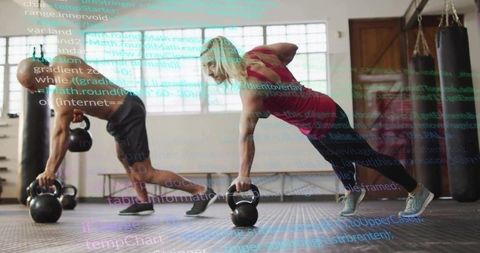 Training partners performing kettlebell renegade rows in gym