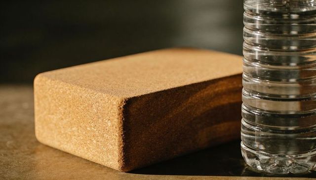 Rectangular cork block resting beside ribbed water bottle under warm studio light