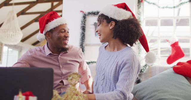 Happy african american couple with santa hats having image call. Spending quality time at christmas together concept.