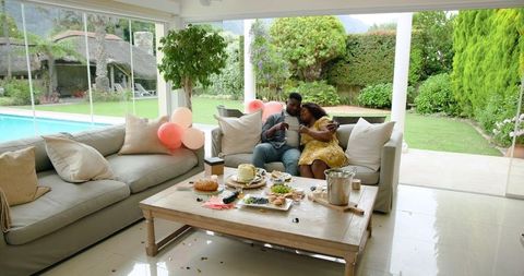 Mature Couple Celebrating with Snacks in Cozy Living Room