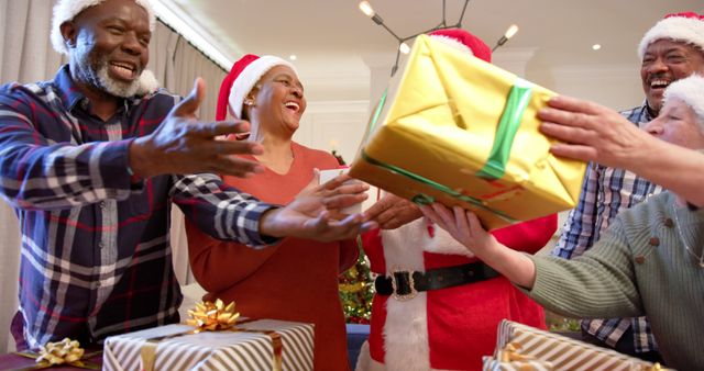 Diverse family exchanging gifts during festive Christmas celebration - Download Free Stock Images Pikwizard.com