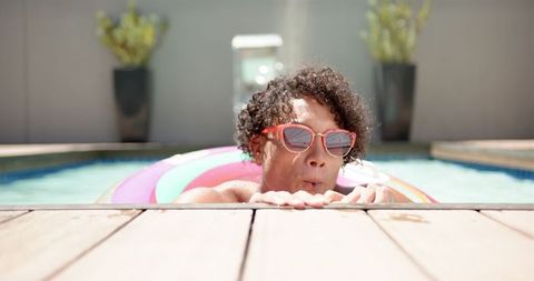 Young Man Chilling on Colorful Float in Home Pool - Download Free Stock Images Pikwizard.com